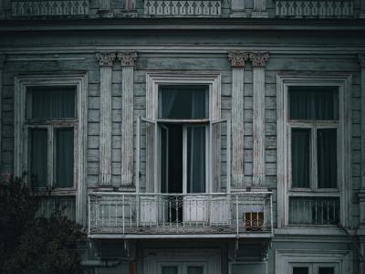 En mørk bygning med en åben terrassedør. 